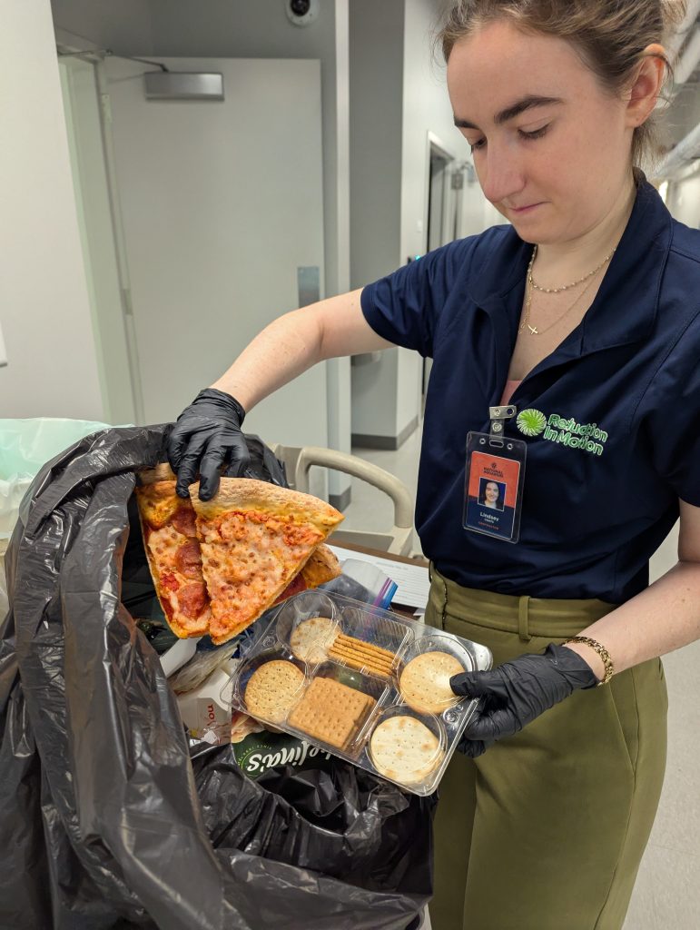 Reduction In Motion staff member hand sorting waste to see recycling and organics diversion potential.