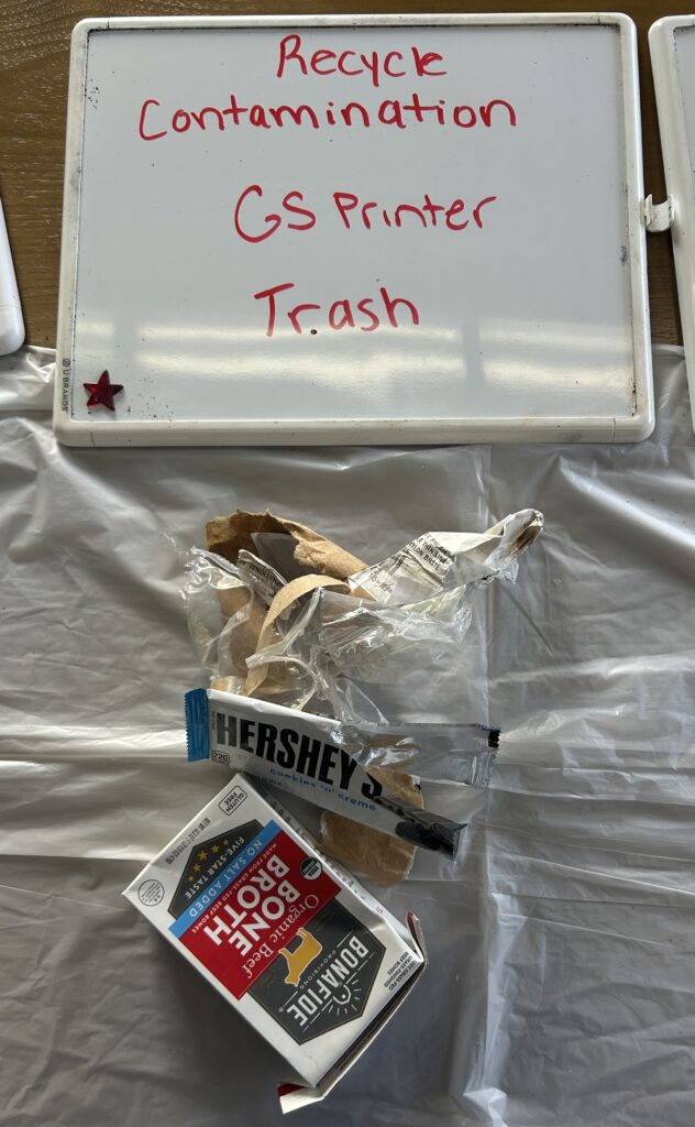 Dry erase board that says recycle contamination GS printer Trash